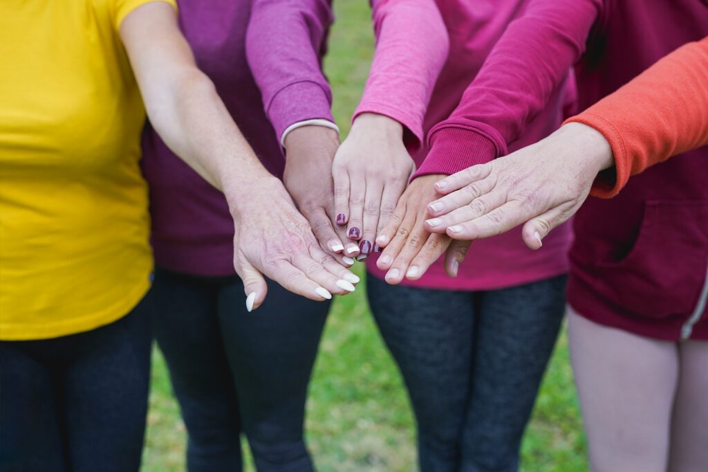 Group of female community stacking hands outdoor